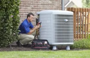  HVAC technician servicing outdoor air conditioning system 