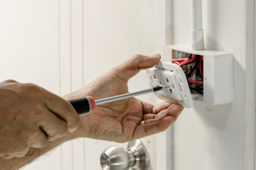 Electrician removing outlet cover in Ohio home