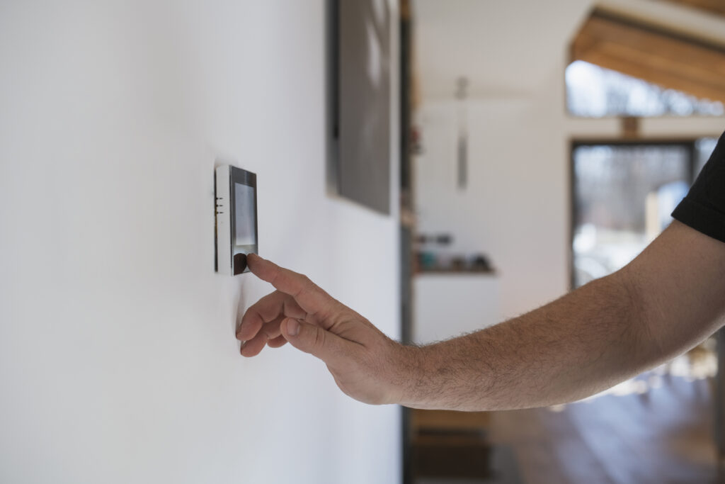 Homeowner adjusting thermostat